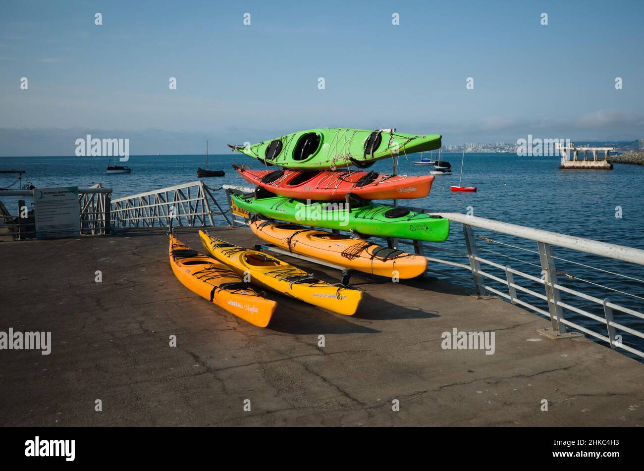 Valparaiso, Chile - February, 2020: Several colorful kayaks stacked on Muelle Baron pier in Bahia de Valparaiso bay of Pacific ocean. Stock Photo