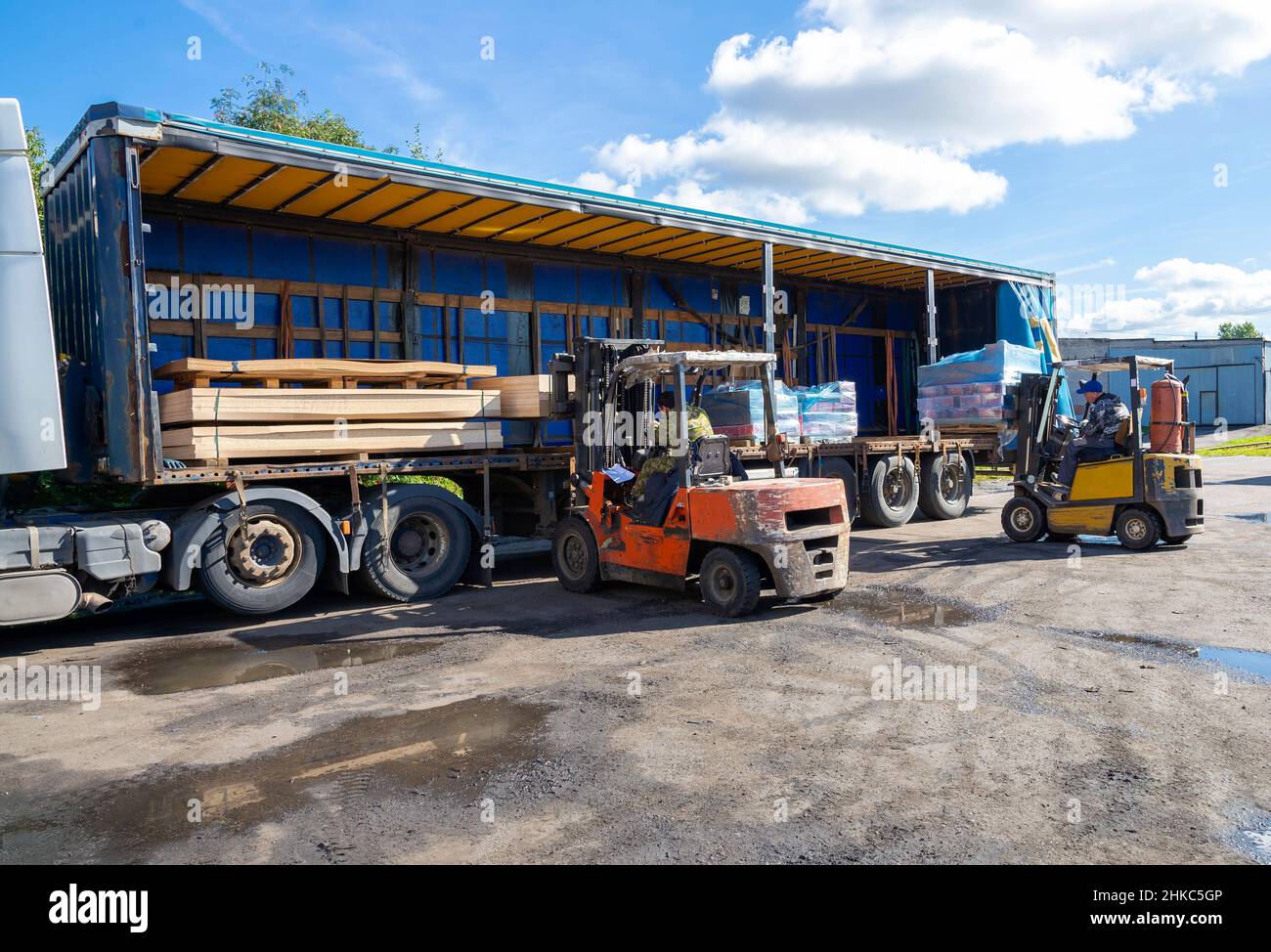 SAINT PETERSBURG, RUSSIA - SEPTEMBER 10, 2021: Two loaders load goods into a semi-trailer Stock Photo