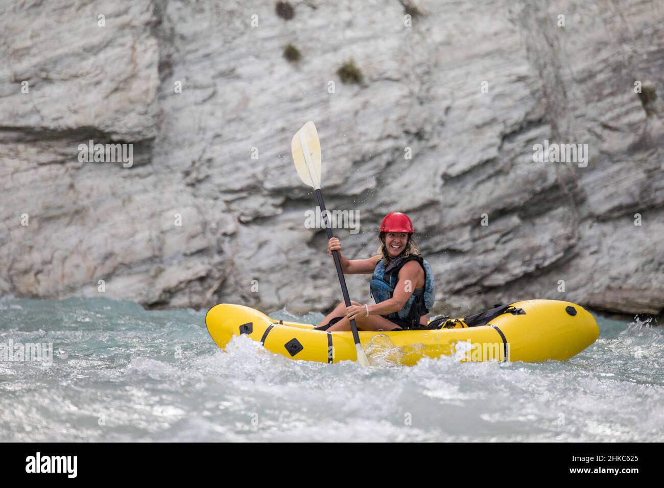 Side view of female paddler in a river canyon. Stock Photo