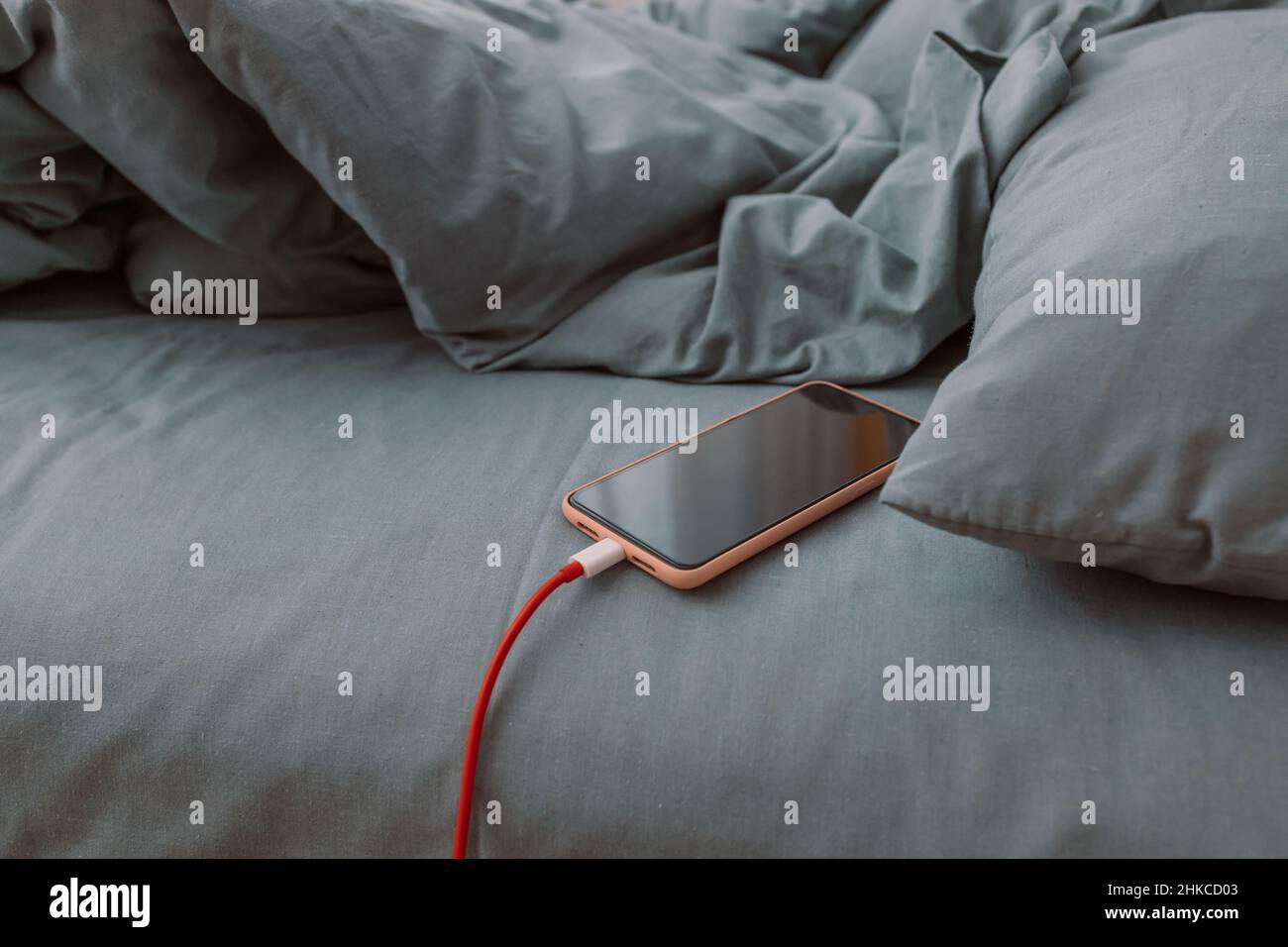 Mobile smart phone charging battery on bed in the bedroom at home