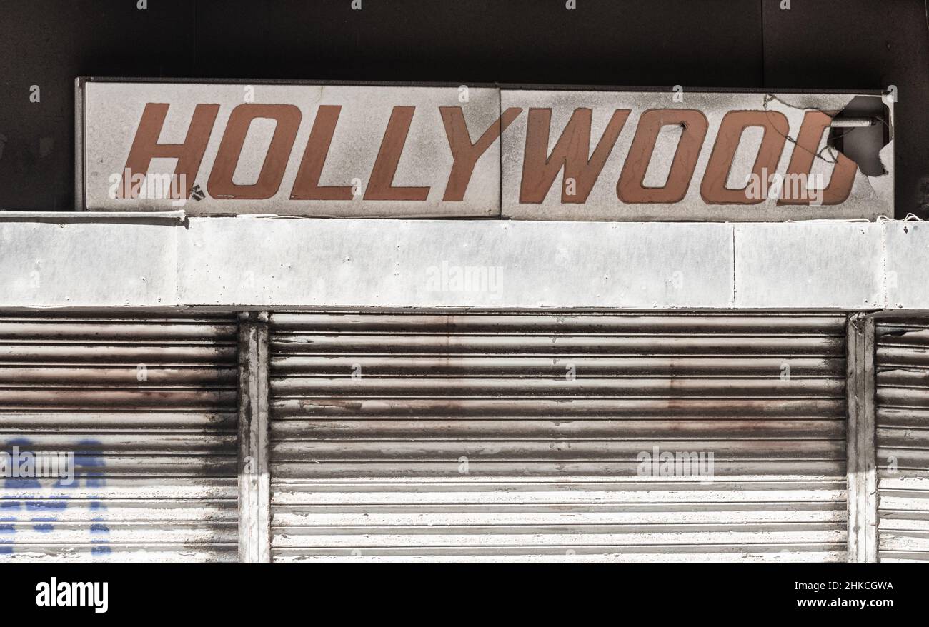 Broken Hollywood neon sign above closed down store. Stock Photo