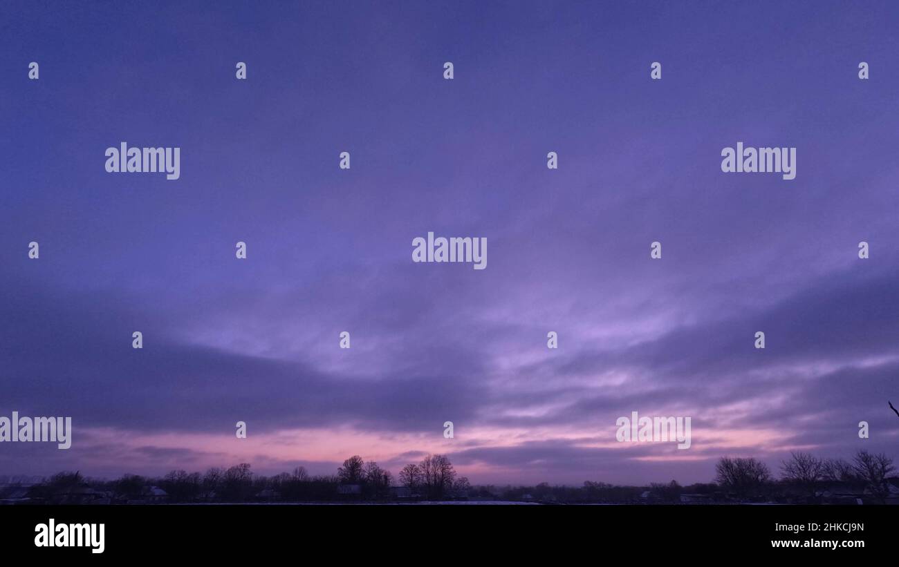 Time lapse sunrise and clouds. Purple beautiful sky in winter Stock Photo