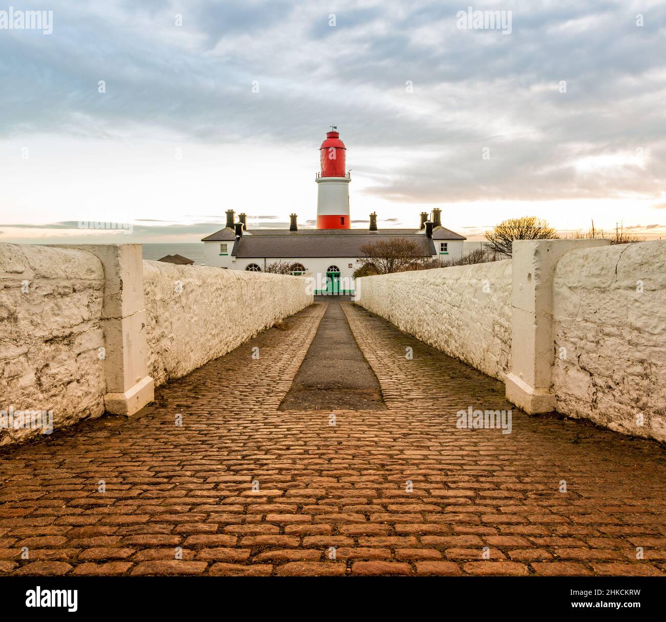 The cobbled pathway to the red and white striped, 23 meter tall,  Souter Lighthouse in Marsden, South Shields as the sun rises Stock Photo