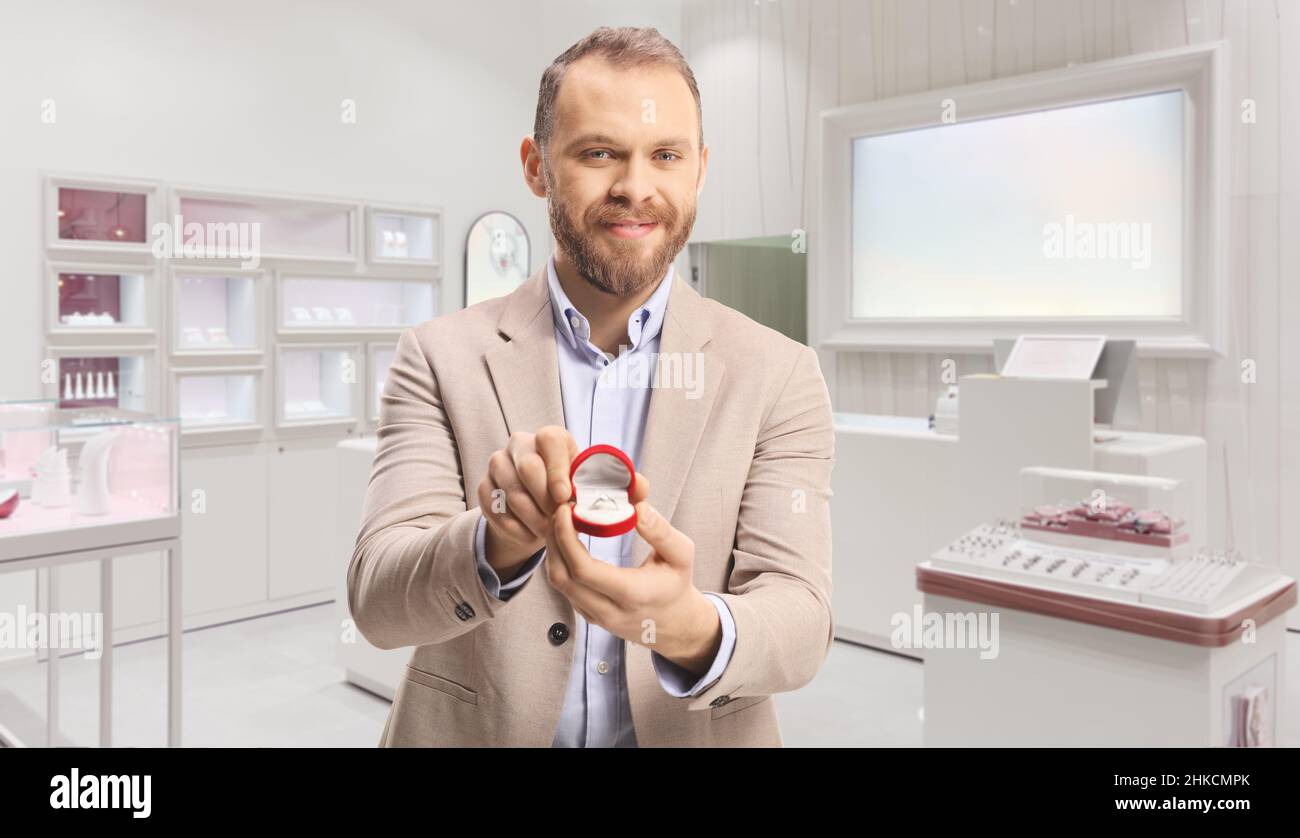 Man holding an engagement ring in a box inside a jewelry store Stock Photo