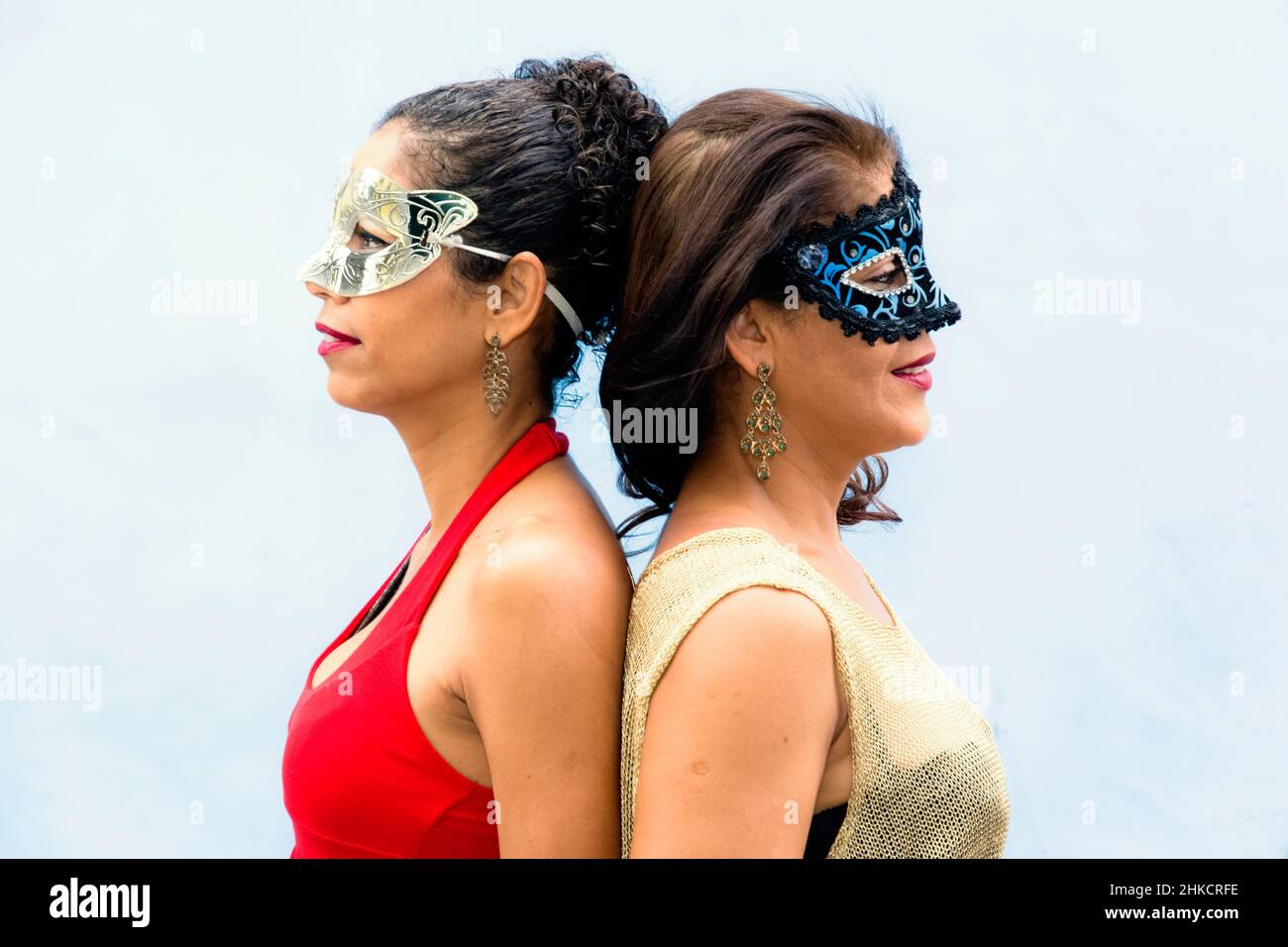 Portrait of two women wearing Venice Carnival mask against light background. Salvador, Bahia, Brazil. Stock Photo