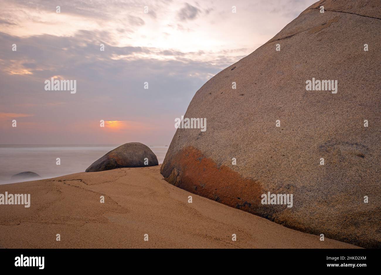 Long exposure sunrise by the big rock boulder beach and Caribbean Sea of Tayrona national park, Colombia. Stock Photo
