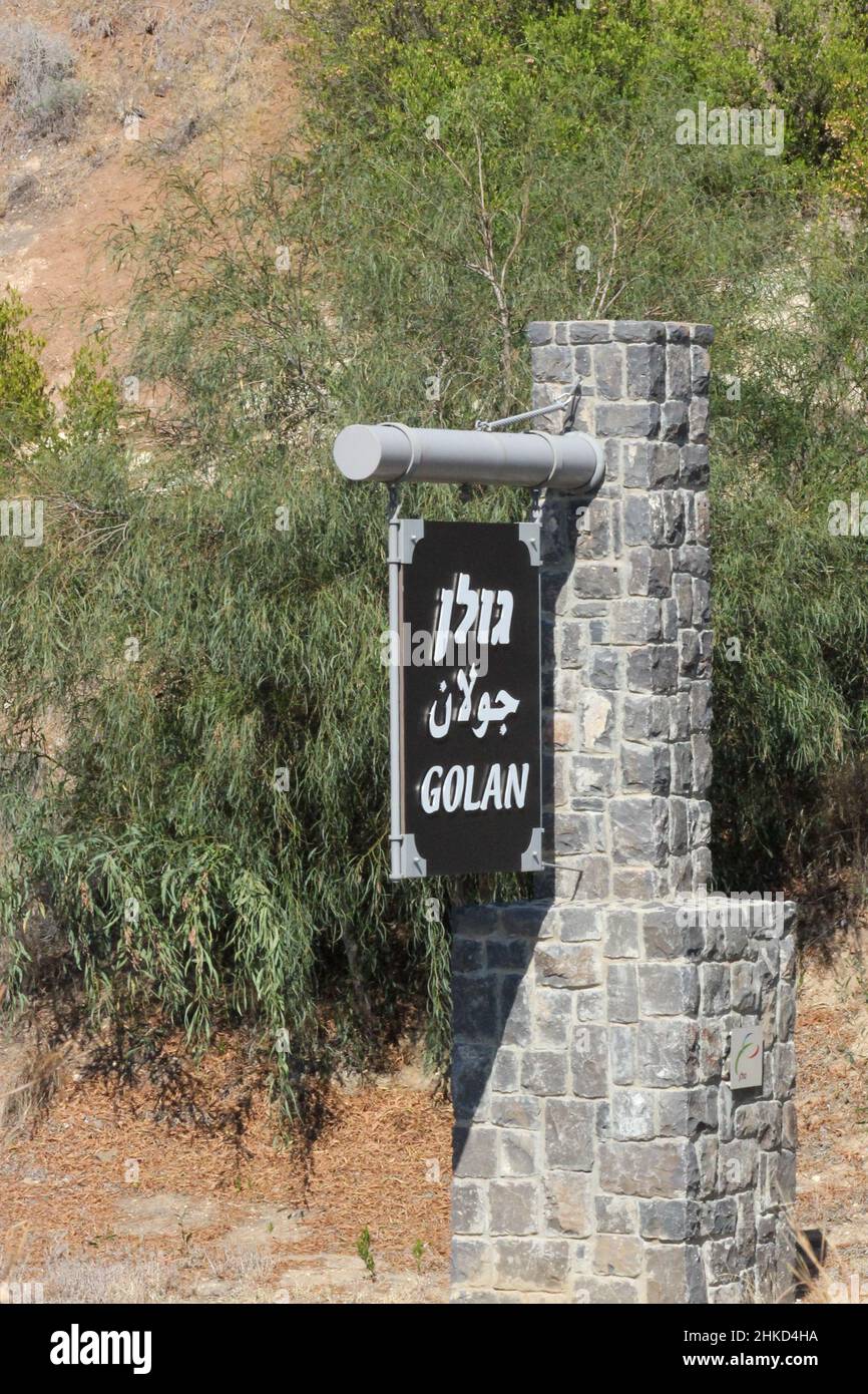 A trilingual monument sign, printed in Hebrew, Arabic and English, designates the Golan Heights in northern Israel. Stock Photo
