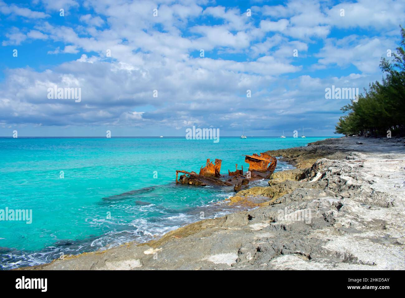 Sailing boats anchored in the clear blue ocean behind the Gallant Lady shipwreck, North Bimini, Bahamas Stock Photo