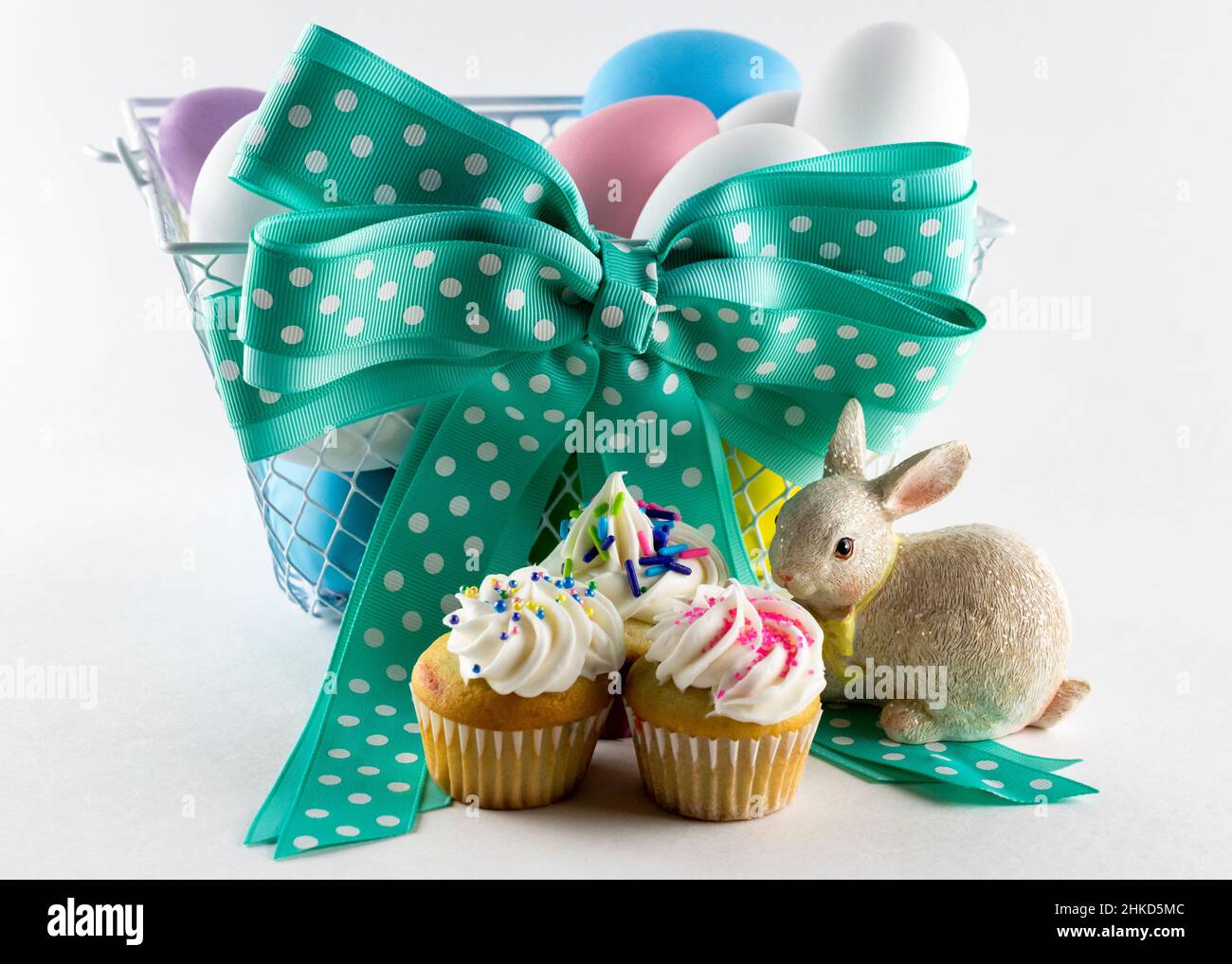 Assorted mini cupcakes with Easter basket in background. Stock Photo