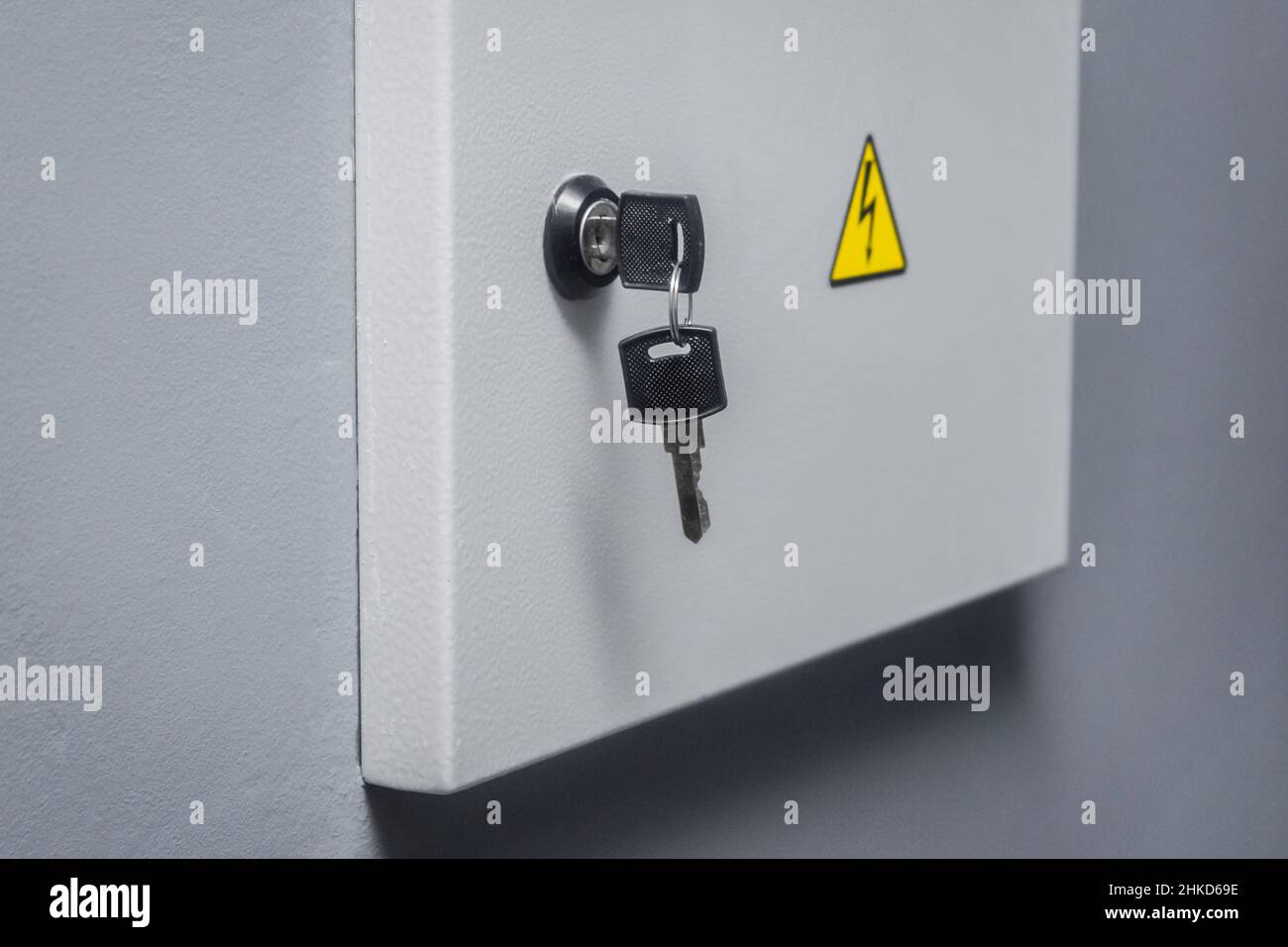 Key in the lock from the electrical power box, caution high voltage on the wall. Stock Photo