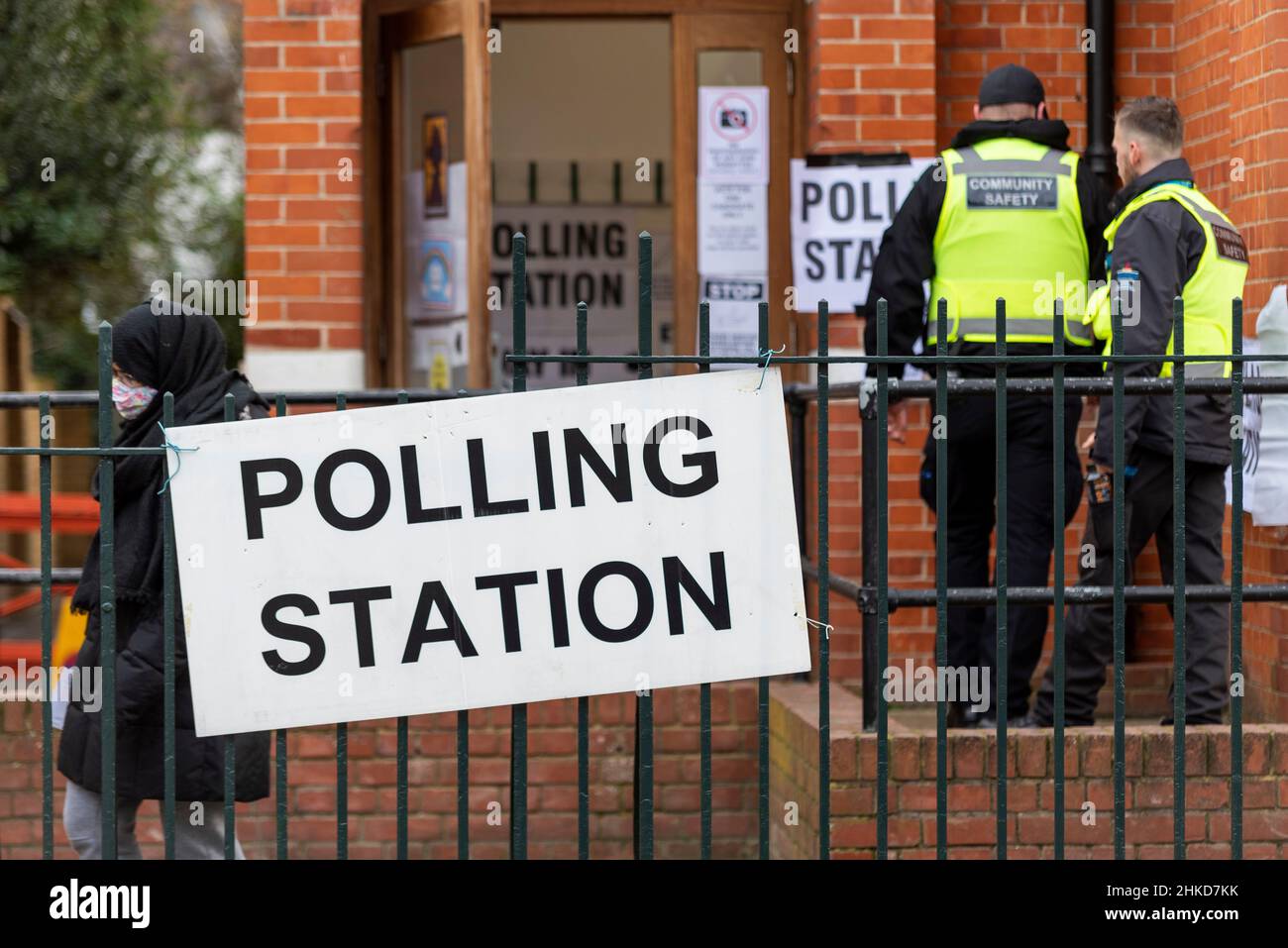 Polling station for the Southend West by-election to replace murdered MP Sir David Amess. Community safety officers entering. Security. Masked voter Stock Photo