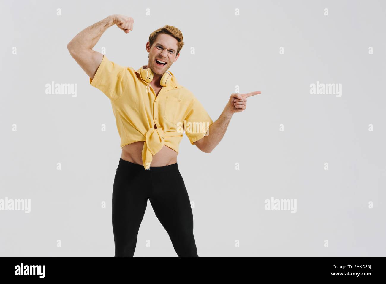 Finger Biceps Ginger young man showing his bicep and pointing finger aside isolated ...