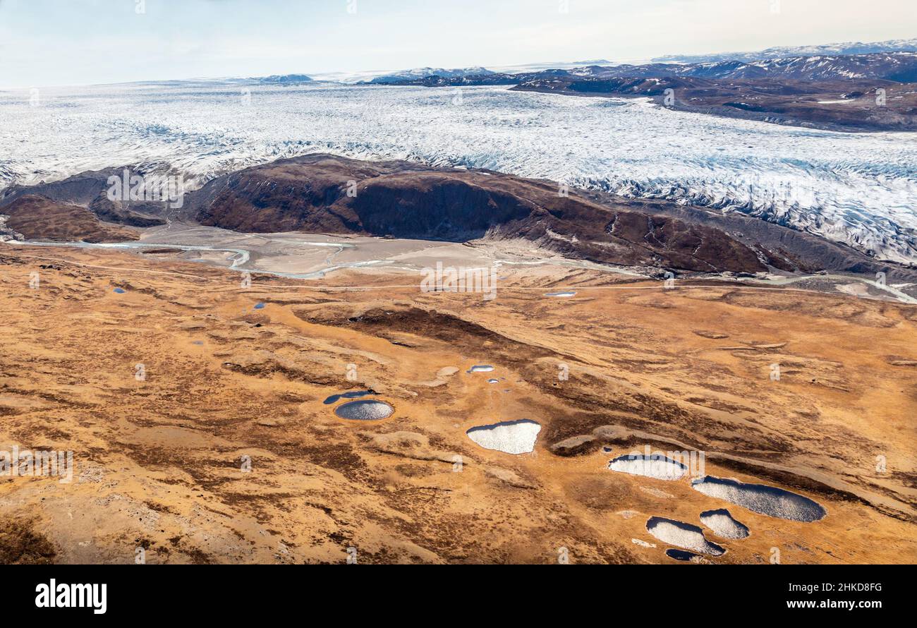 Greenlandic ice sheet melting glacier into river with tundra aerial view, near Kangerlussuaq, Greenland Stock Photo