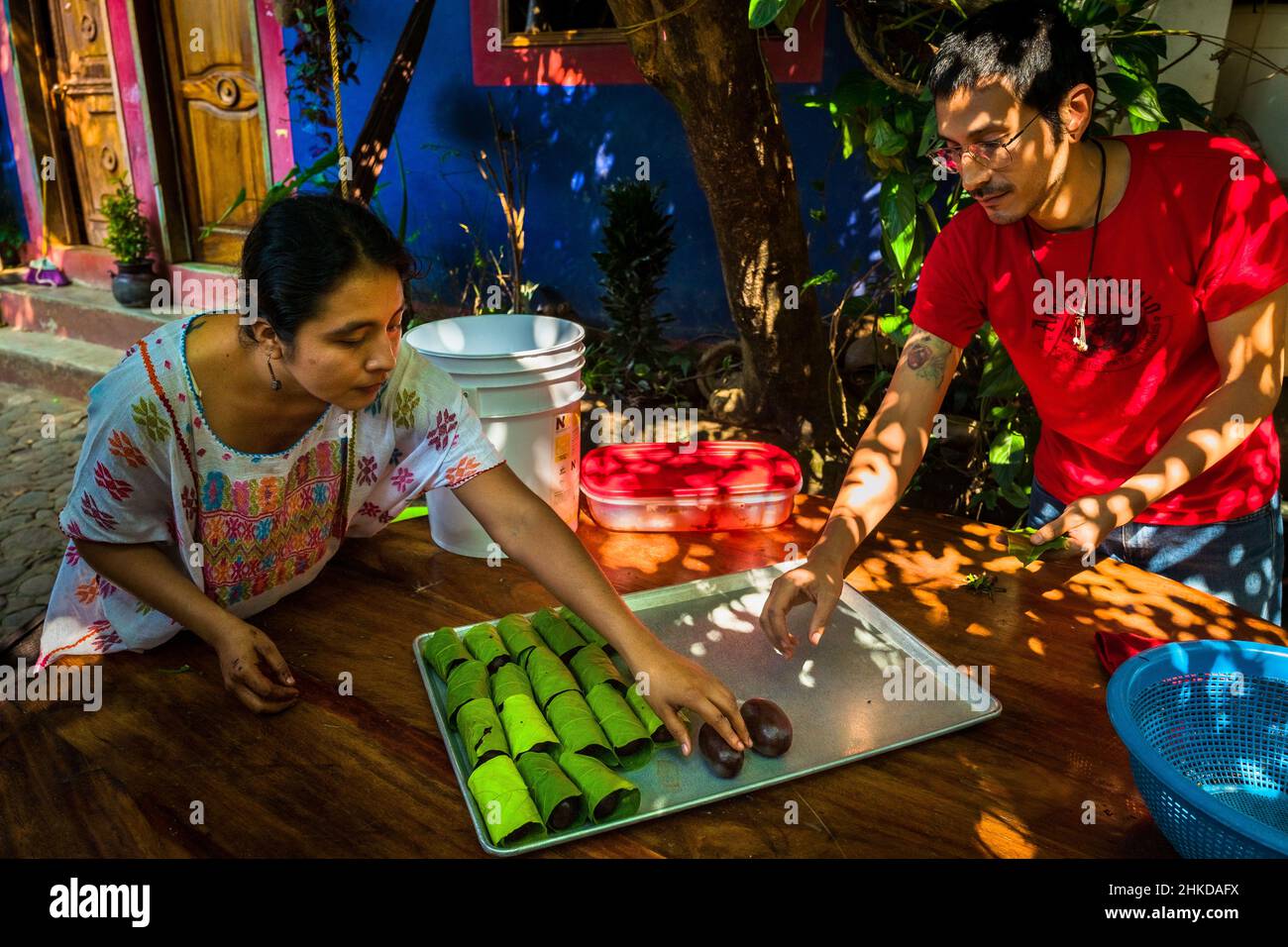 An indigenous woman, with her husband, wraps chocolate balls made of raw cacao paste in artisanal chocolate manufacture in Xochistlahuaca, Mexico. Stock Photo