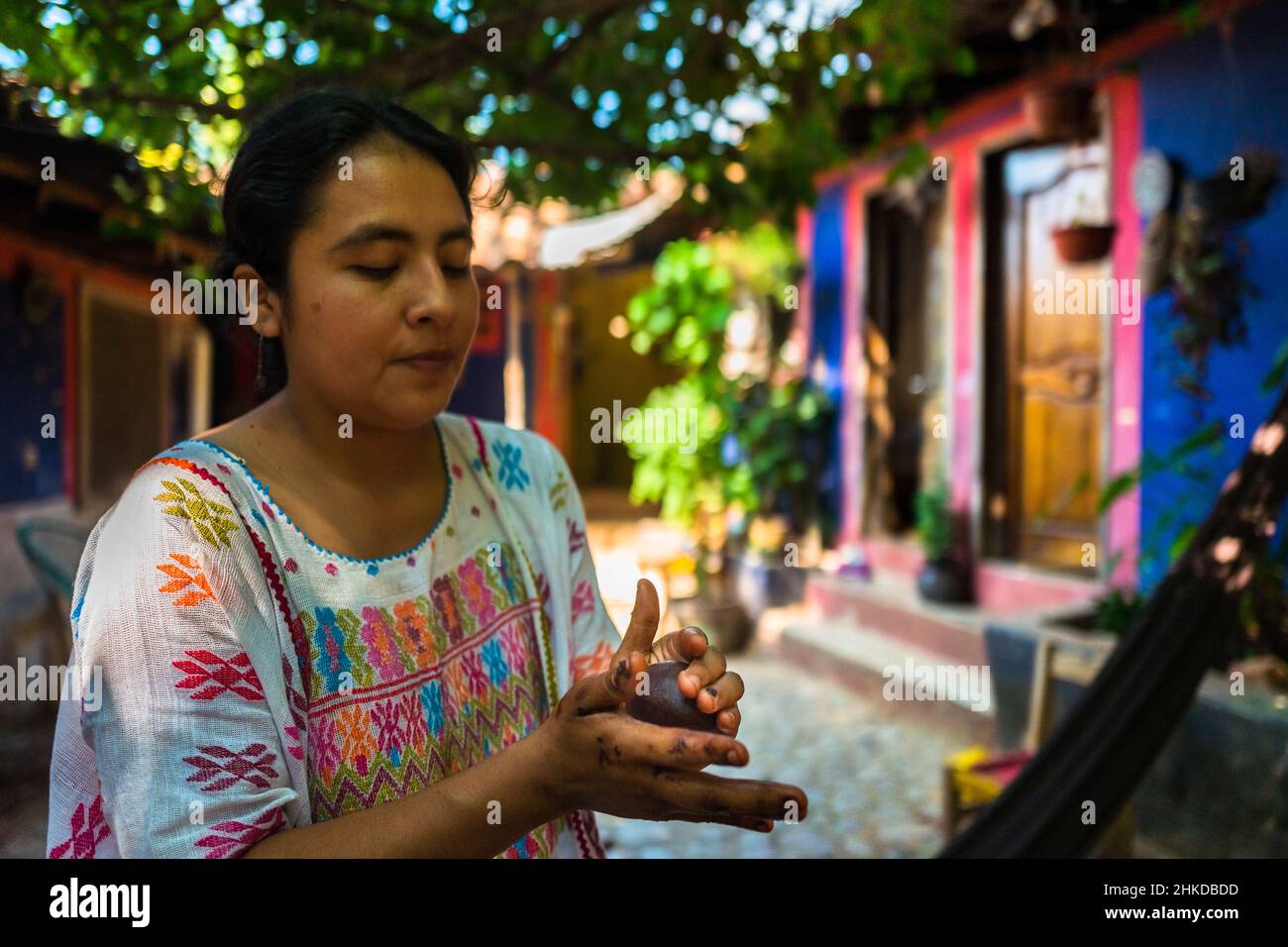 An indigenous woman rolls the raw cacao paste into balls, used for hot chocolate, in artisanal chocolate manufacture in Xochistlahuaca, Mexico. Stock Photo