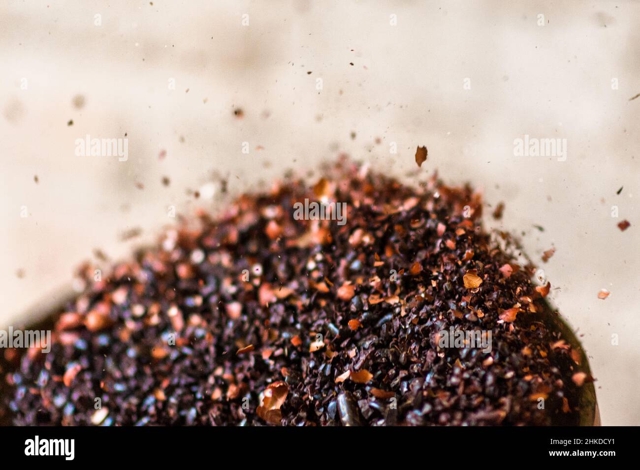 A winnowing bowl, full of crushed cacao beans tossed into the air, is seen being shaked in artisanal chocolate manufacture in Xochistlahuaca, Mexico. Stock Photo