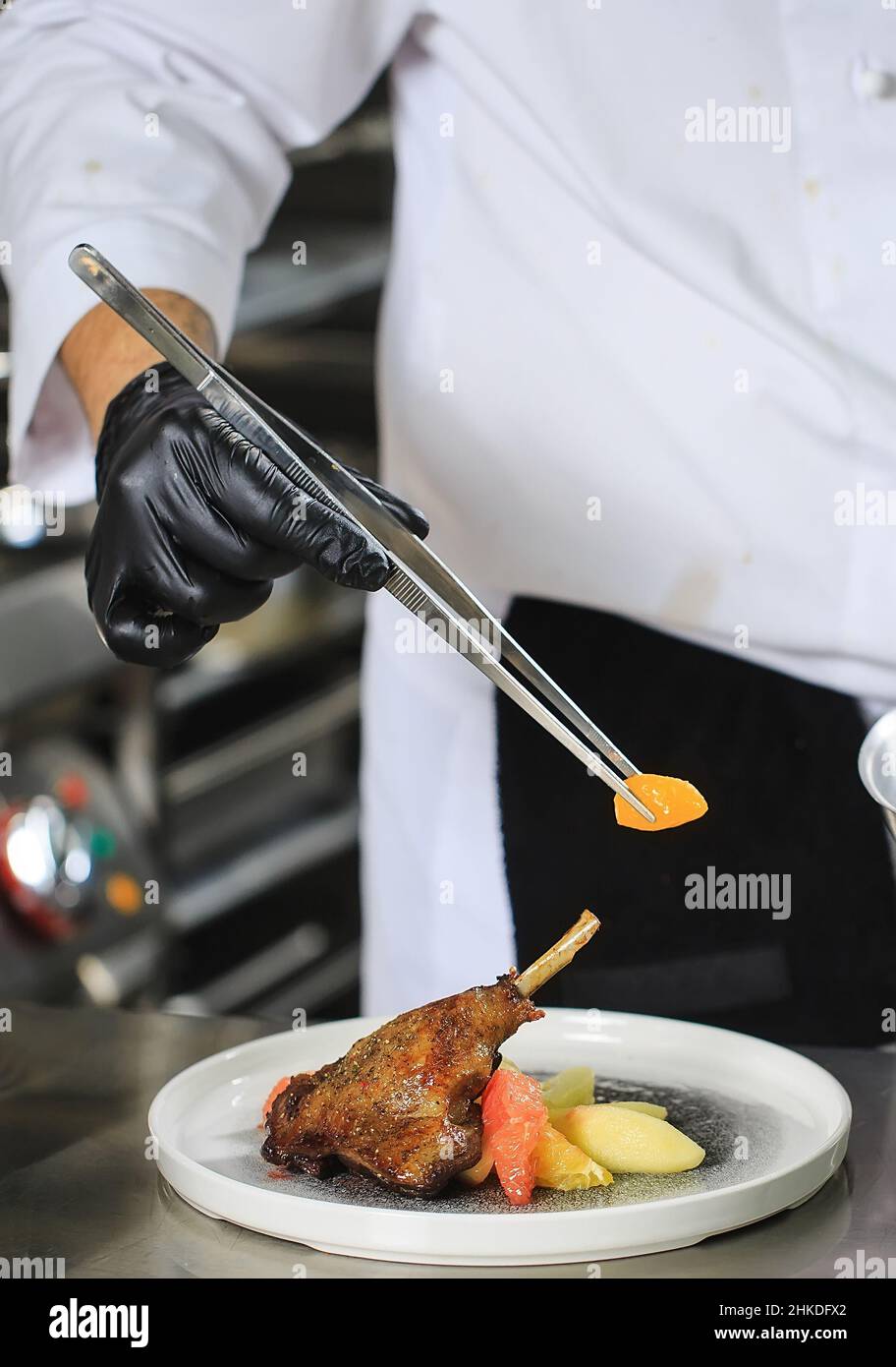 Chef Preparing Dish In Kitchen. Decorating Dish Stock Photo