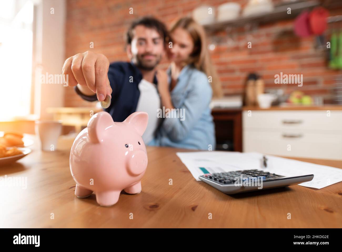The couple saves money. Inserting a coin into a piggy bank Stock Photo ...