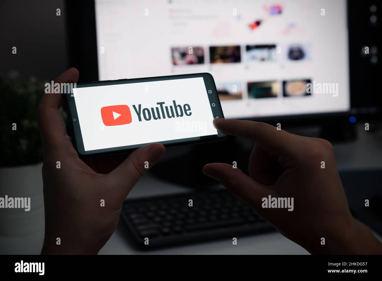 Wroclaw, Poland - JAN 27, 2022: Man holding device with YouTube logo on screen. YouTube is most popular video service developed by Google. Stock Photo