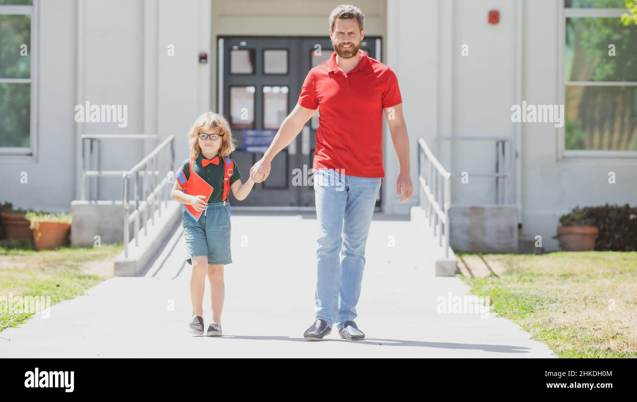 Outdoor school. School boy going to school with father. Parent with