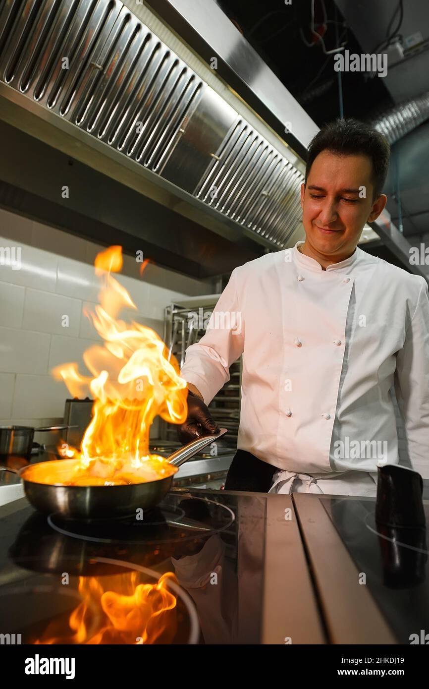 Close-up of the chef's hands cooking food on fire. The chef burns food ...