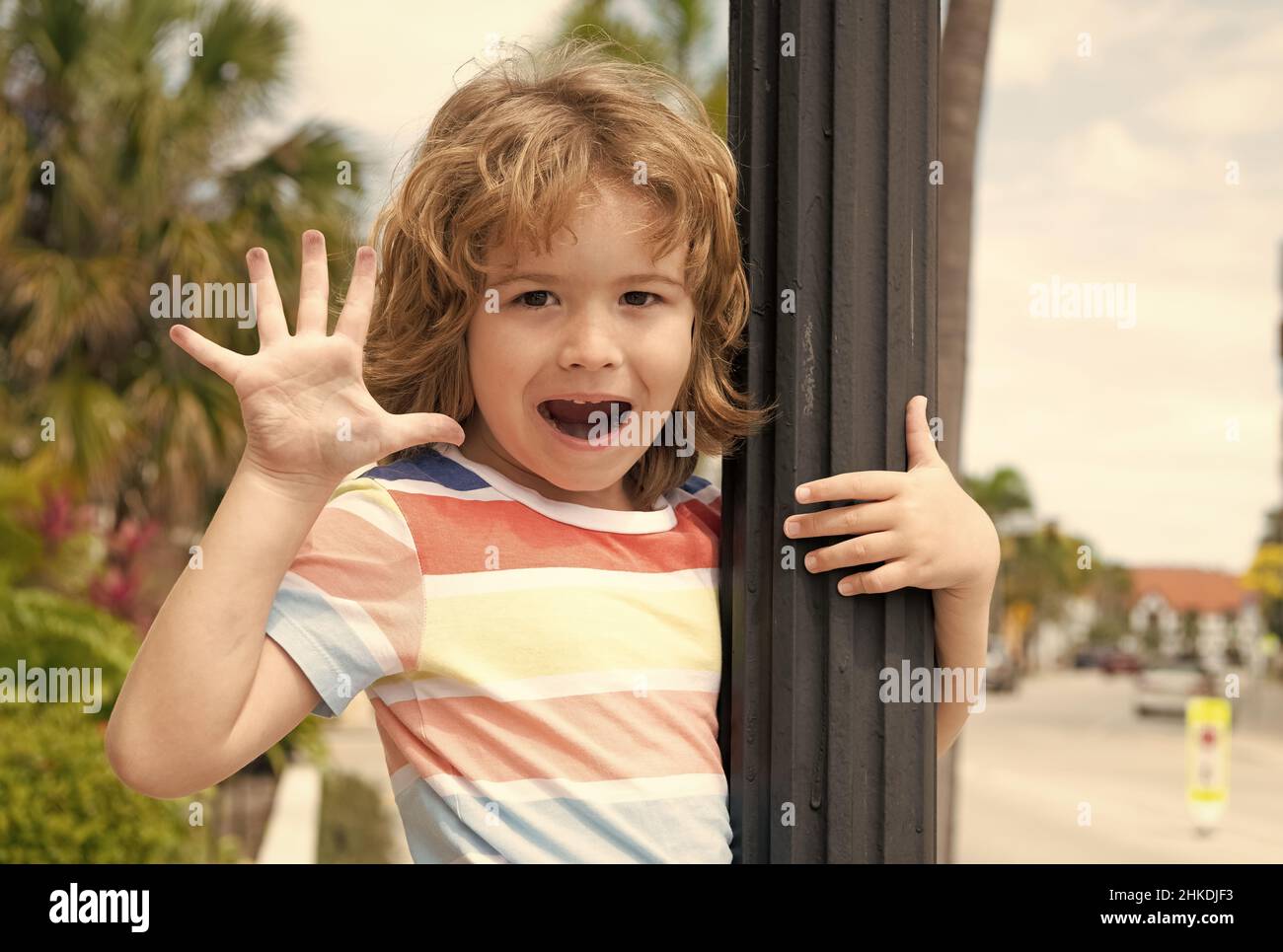Happy boy kid open hand showing five fingers in greeting summer outdoors, hifive Stock Photo