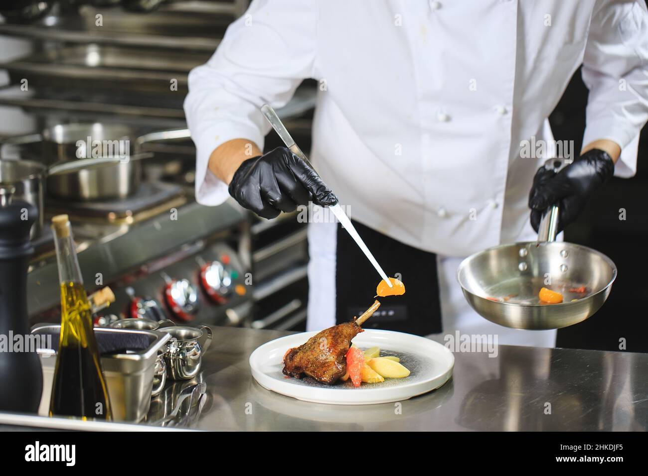 Chef Preparing Dish In Kitchen. Decorating Dish Stock Photo