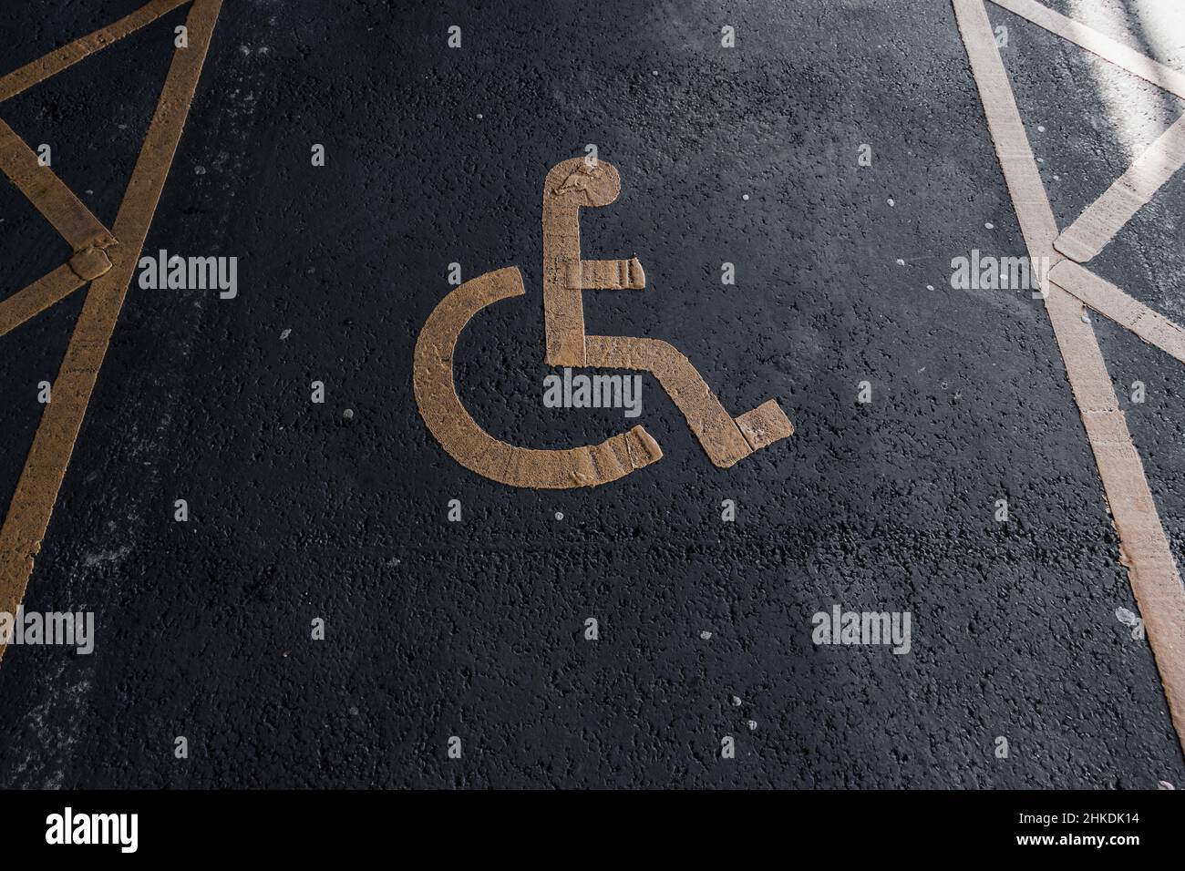 Disabled parking. Accessible parking spot. Blue badge. Yellow wheelchair sign on the ground Stock Photo