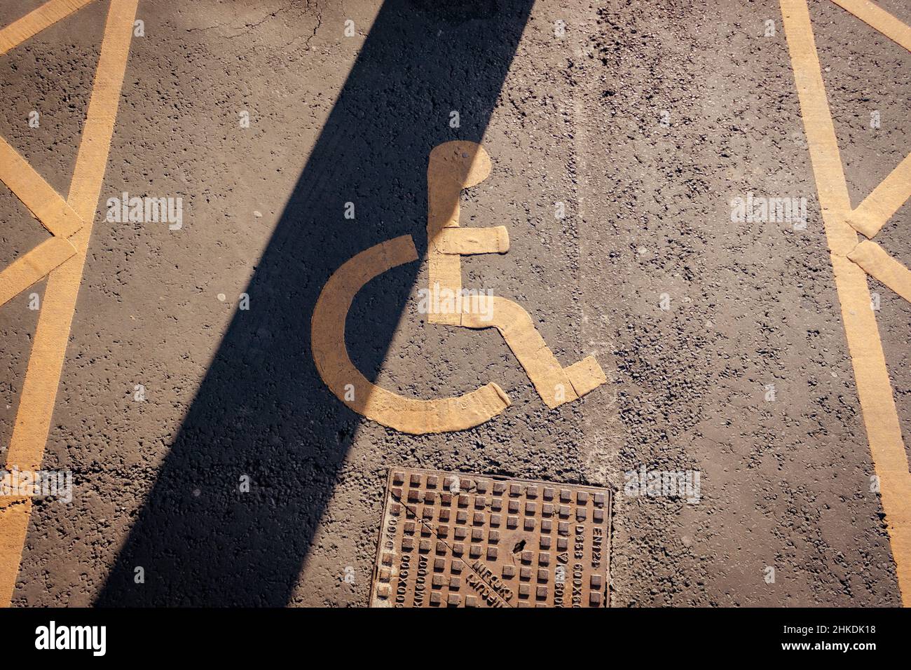 Disabled parking. Accessible parking spot. Blue badge. Yellow wheelchair sign on the ground Stock Photo