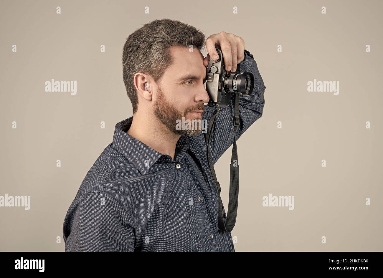 Unshaven photojournalist in casual style shirt take photograph with handheld photo camera, paparazzi Stock Photo