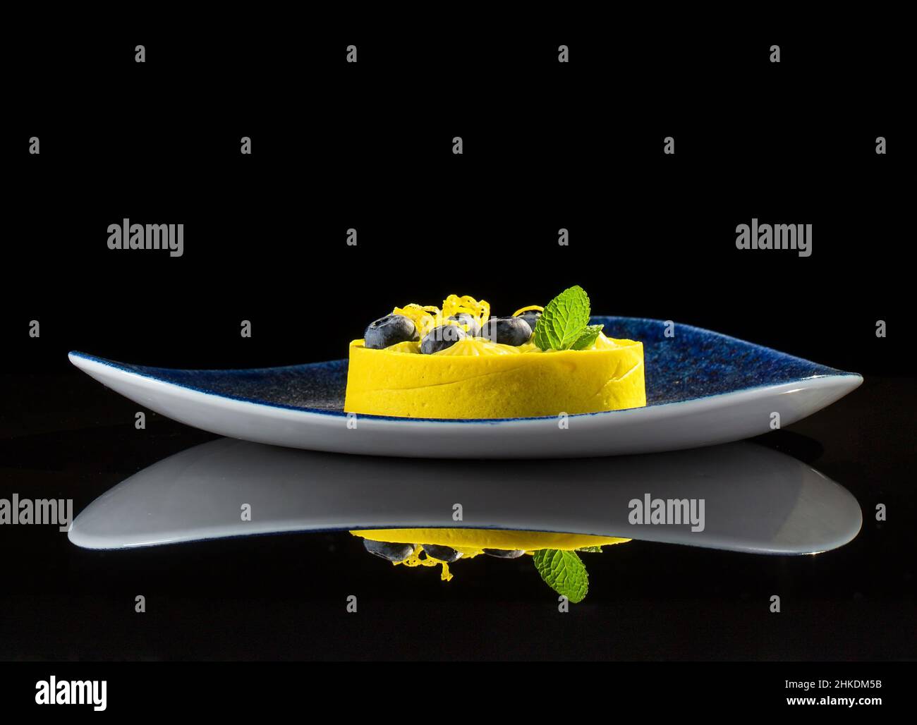 Yellow light dessert on a black background with reflection Stock Photo