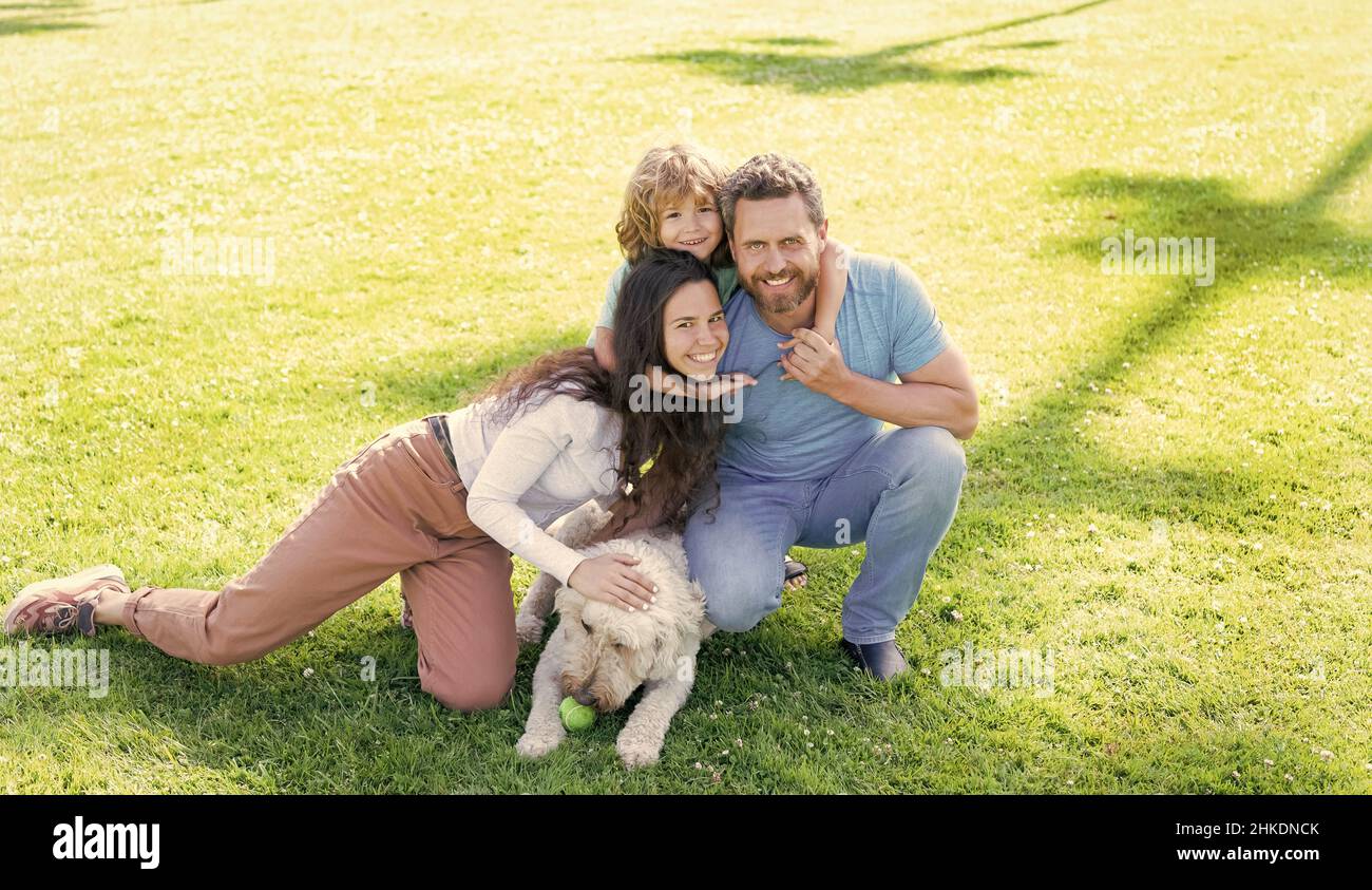 happy parents with kid boy play with dog. mom dad and son love relax ...