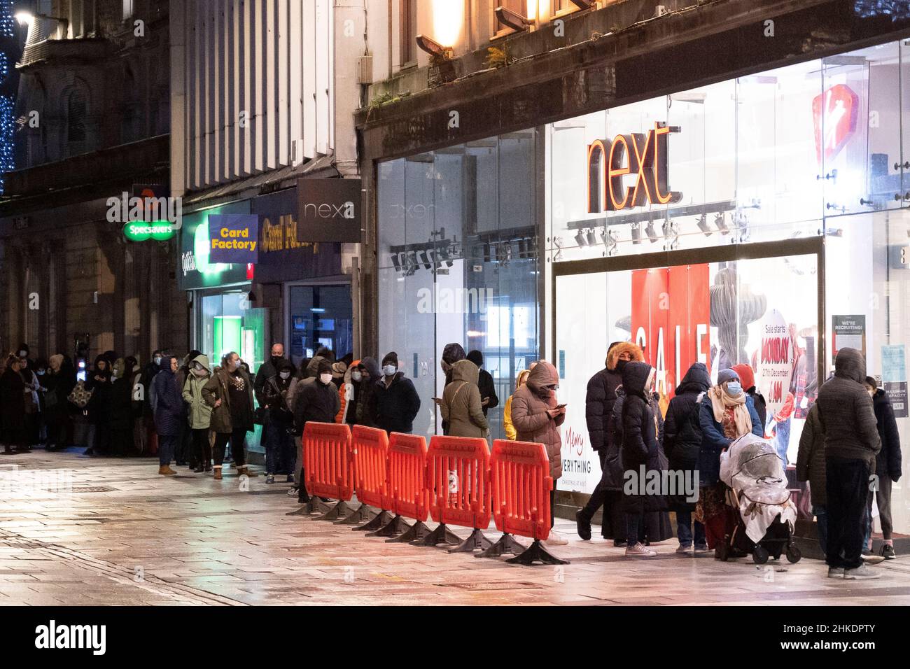 People queue outside a Next store on Queen Street in Cardiff, Wales, United Kingdom for the Boxing Day sales. Stock Photo