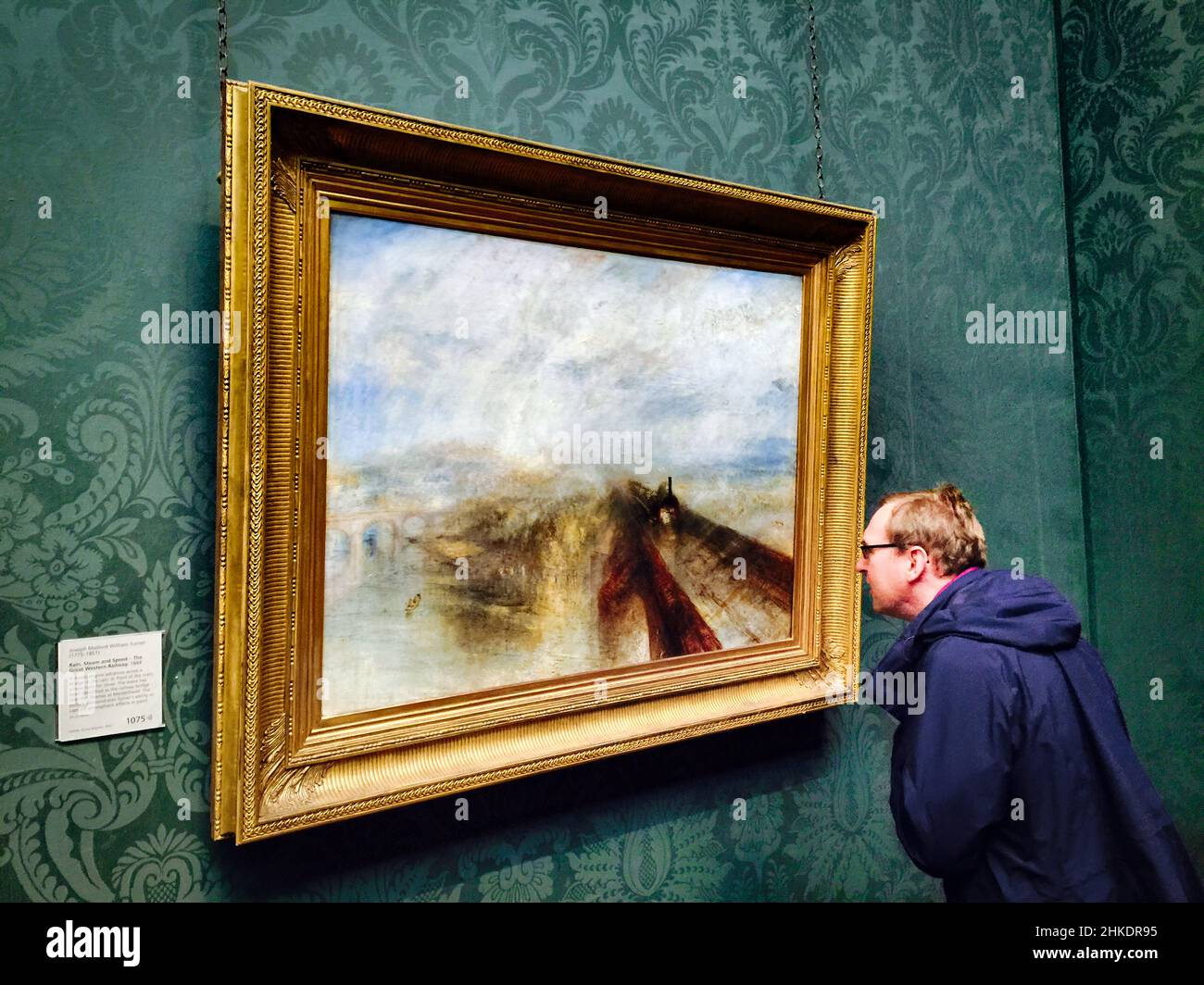 Visitor looking at .M.W. Turner's masterpieces in the National Gallery, London: Rain, Steam and Speed The Great Western Railway, 1844 Stock Photo