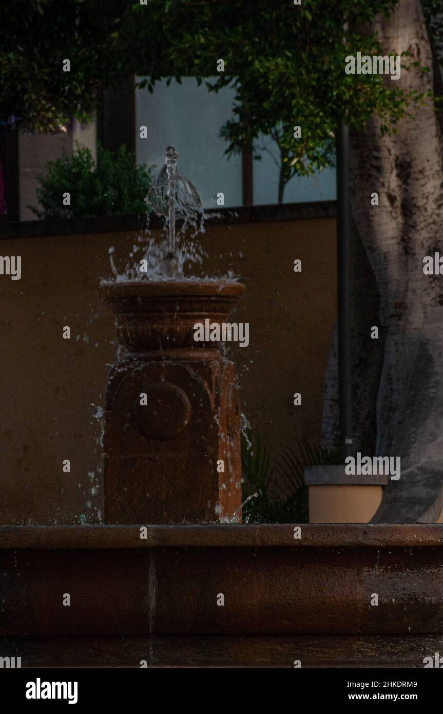 Closeup of a fountain gushes the water in the center of the square Stock Photo