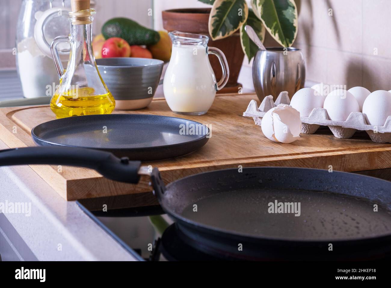 Workplace in the kitchen with ingredients and utensils for baking pancakes. Home cooking food, DIY. Selective focus. Stock Photo