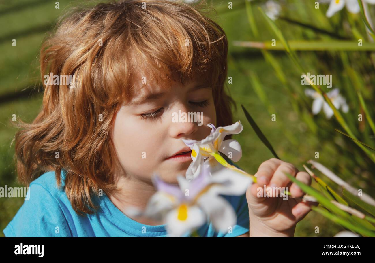 Flower allergy in kids. Spring park with flowers. Little boy sniffing