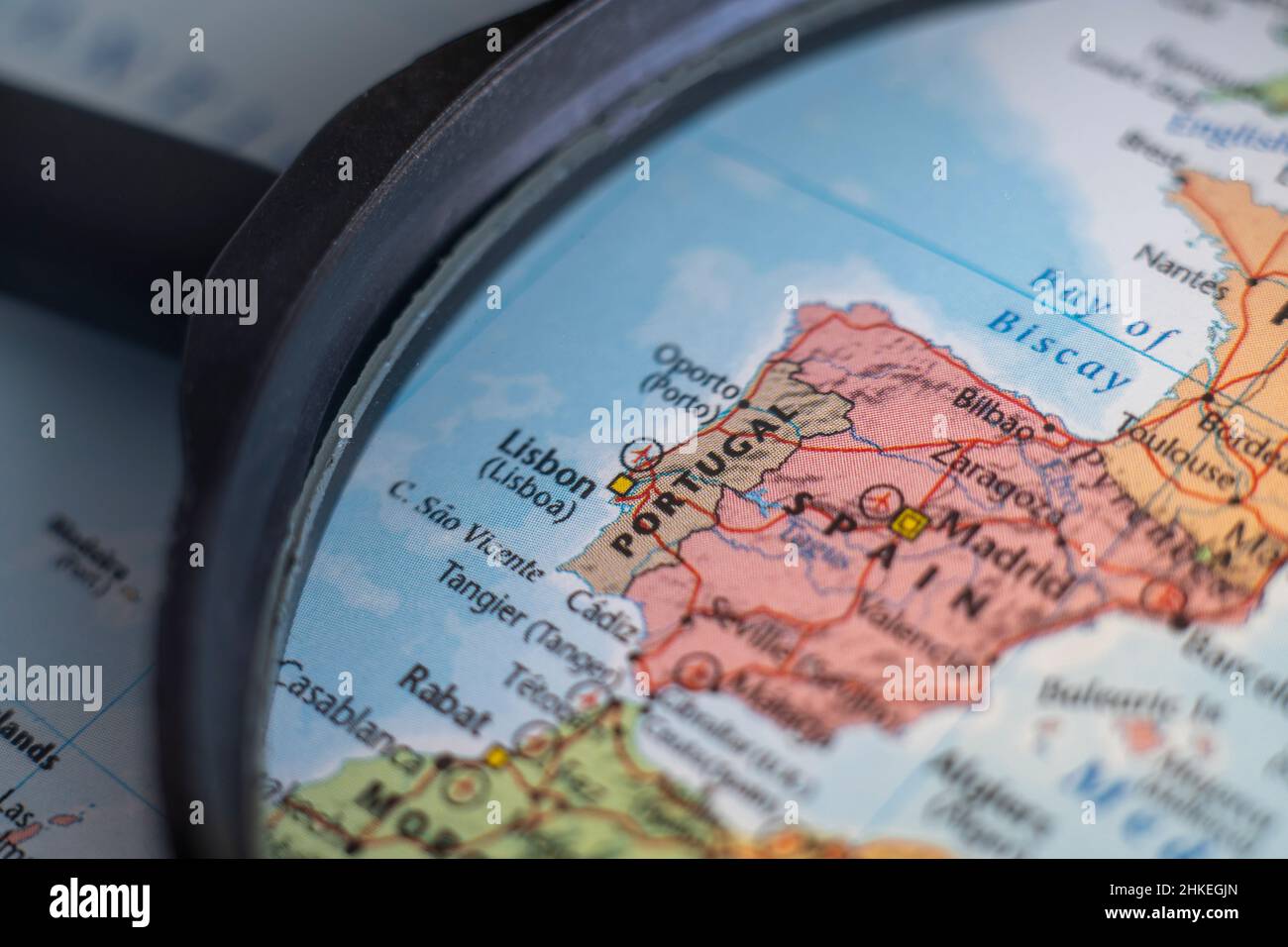 Portugal on a world map through magnifying glass. Portugal travel destination planning pinned Stock Photo