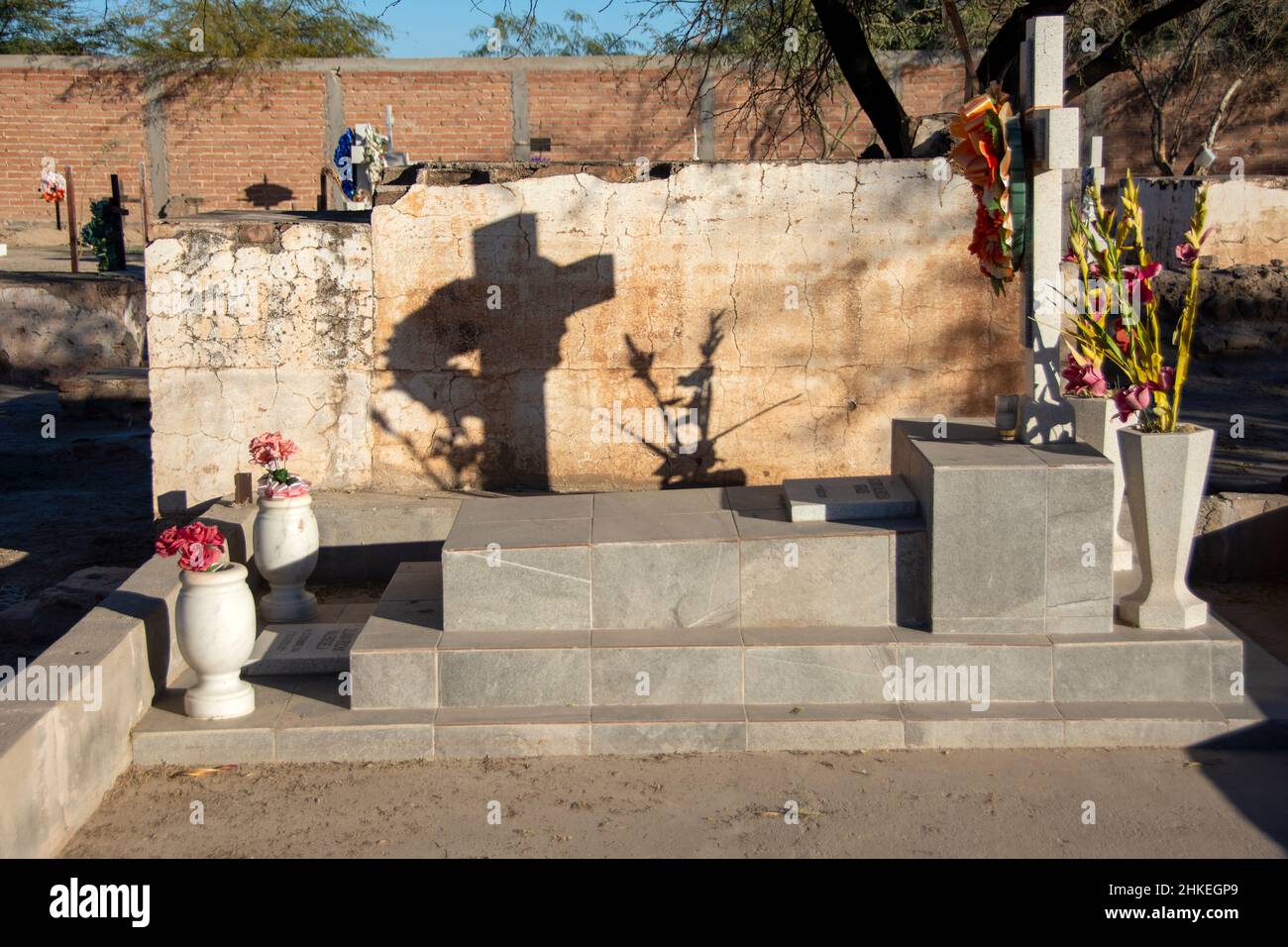The shadow of a cross on another gravesite, Sonoyta, Sonora, Mexico. Stock Photo