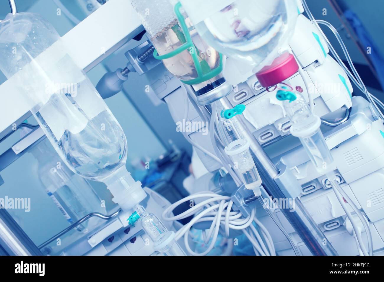 Intravenous drip with saline bottles on the background of digital equipment. Stock Photo