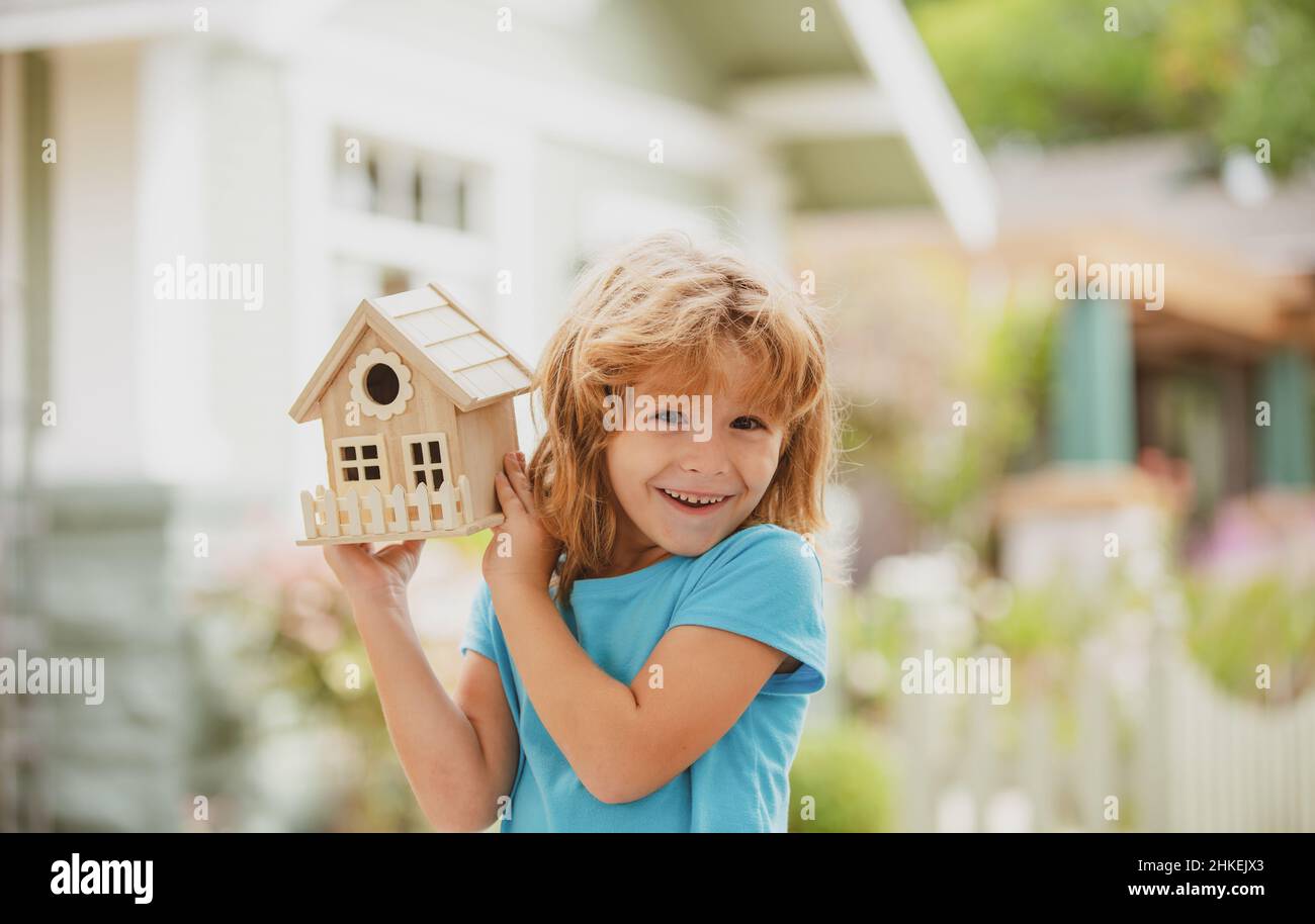 House in kids hands. Family home, home protecting insurance concept, Child boy building house, home care. Happy kid needlework concept. Diy project. Stock Photo