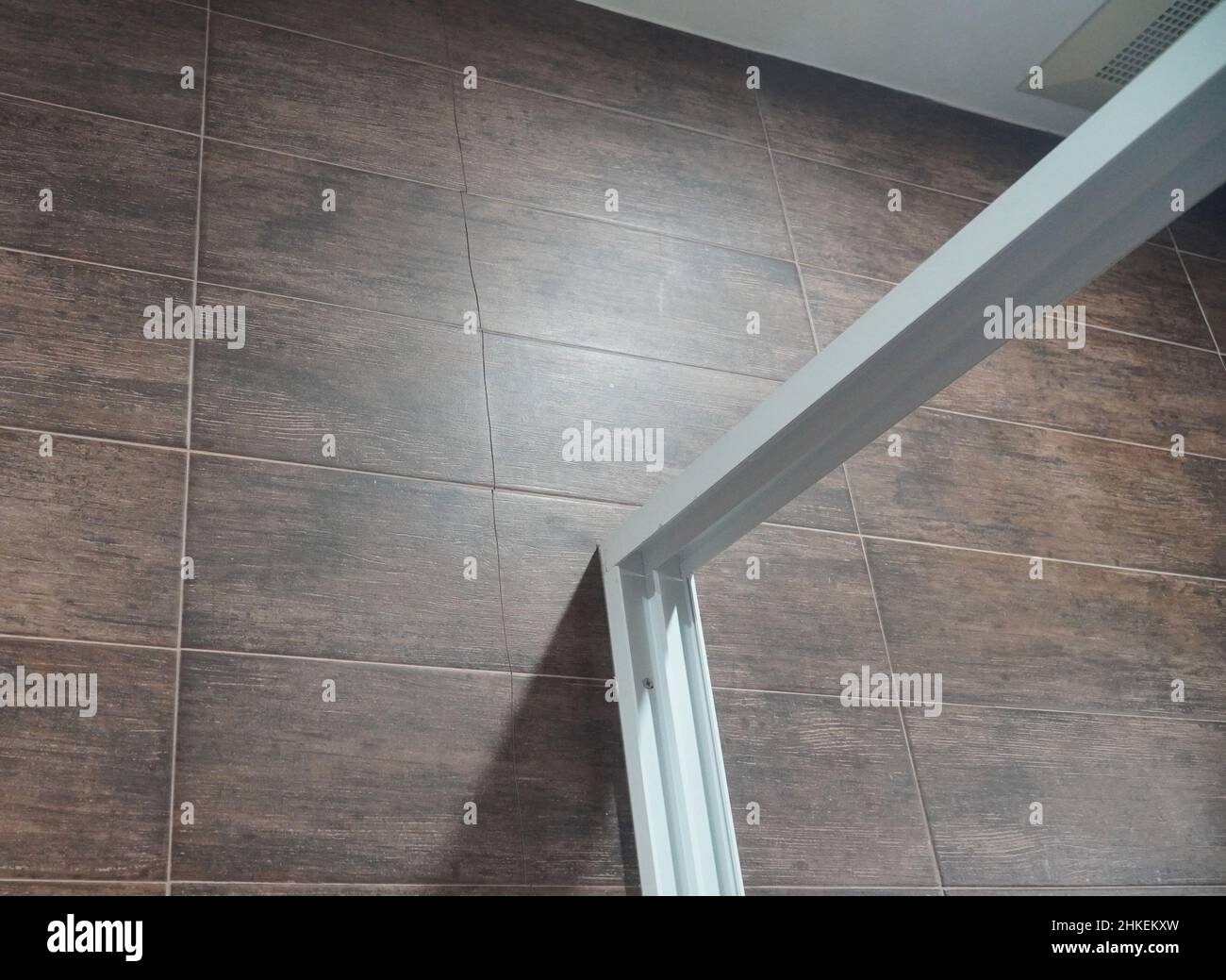 Cracked tile wall in the bathroom. Building problems and solutions concept Stock Photo Alamy