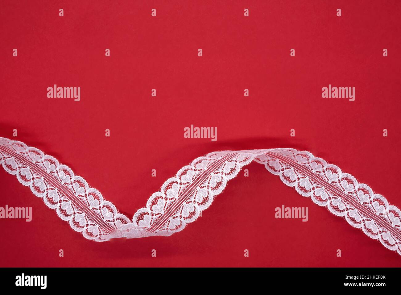 background  lace ribbon with hearts on red background Stock Photo