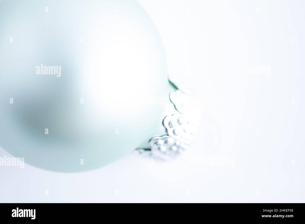 light turquoise colored bauble against white background, high key Stock Photo