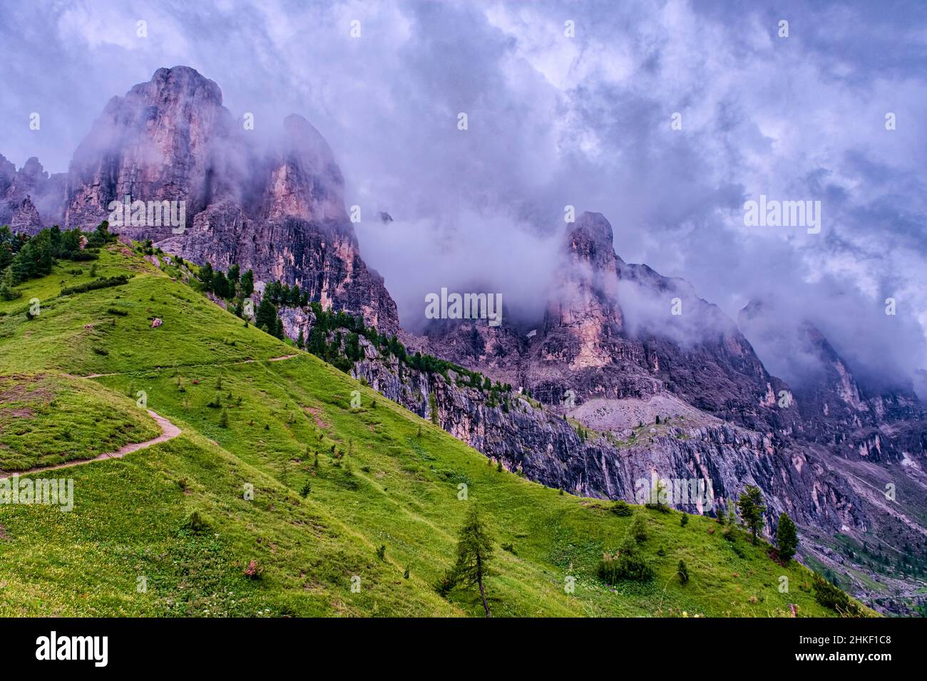 View of the Sella group with the summit of Sas dla Luesa left and Murfeit tower right, covered in dark thunderstorm clouds, seen from Gardena Pass. Stock Photo
