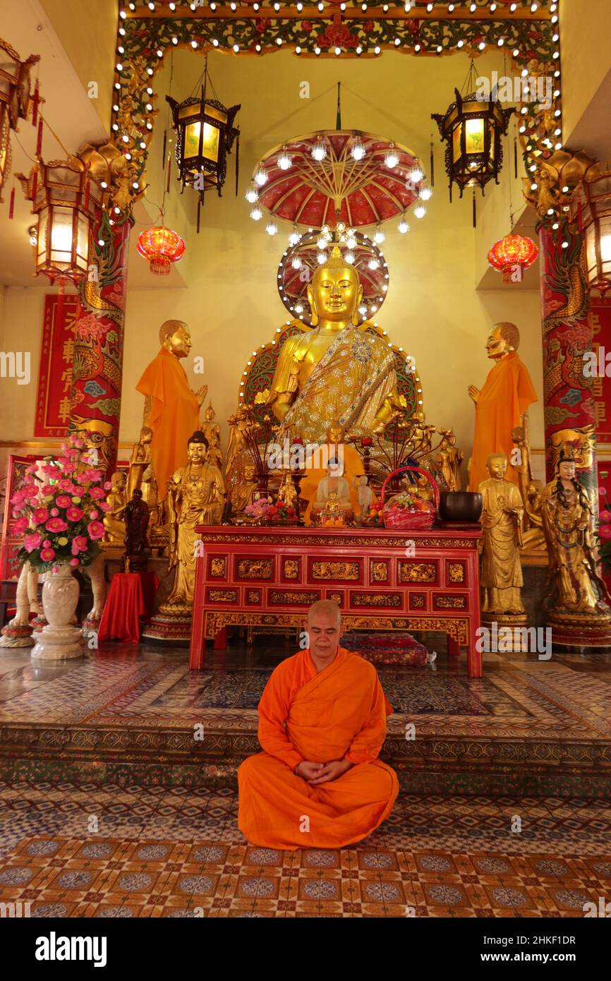 Meditating Buddhist  Monk in lotus position in Temple, Bangkok,Thailand Stock Photo