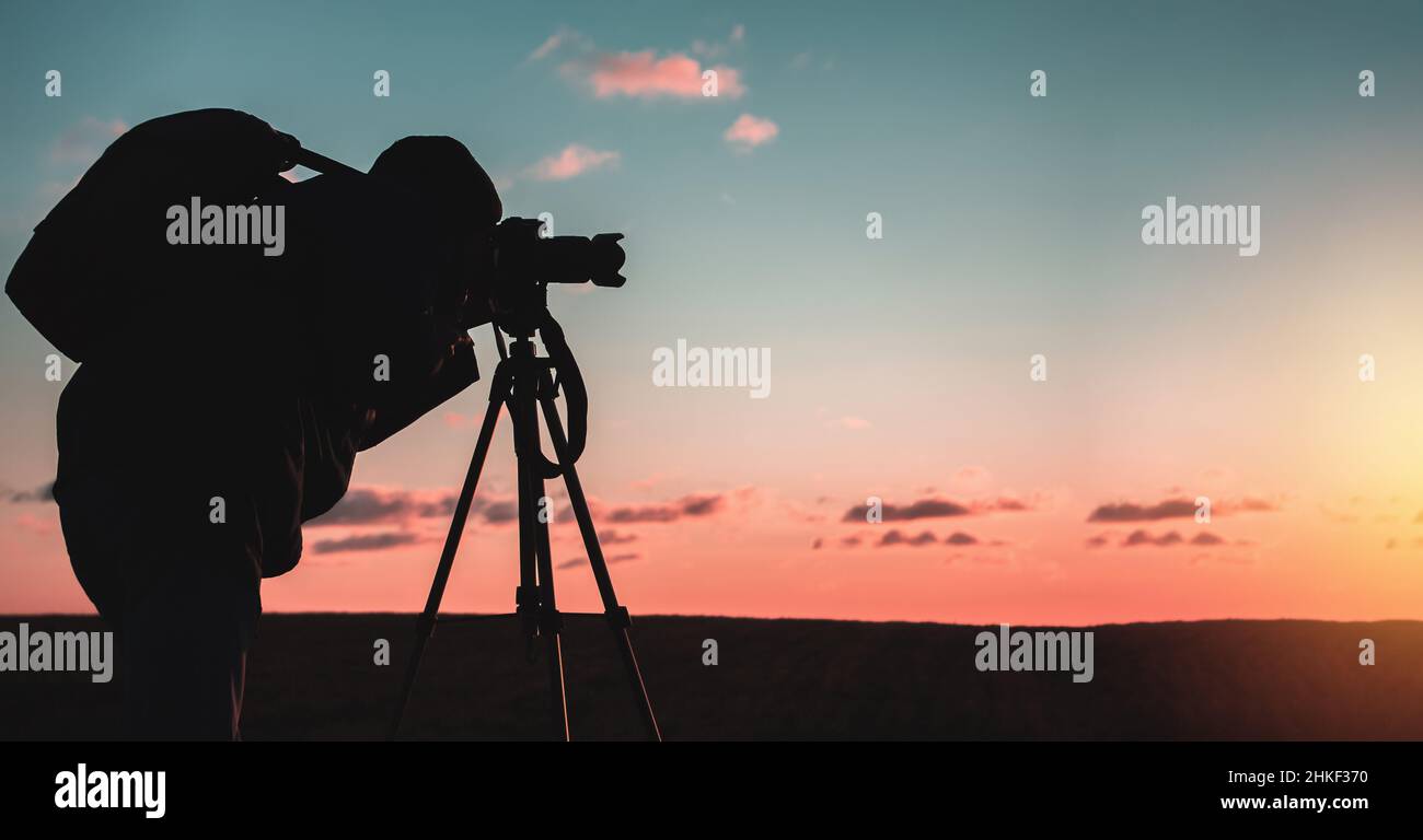 Silhouette of a photographer on a sunset background with a tripod Stock ...