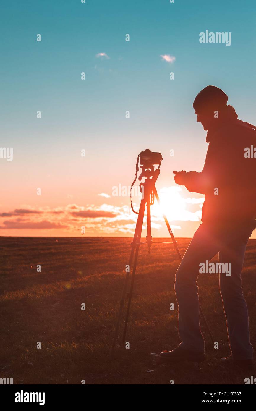 Silhouette of a photographer on a sunset background with a tripod Stock ...