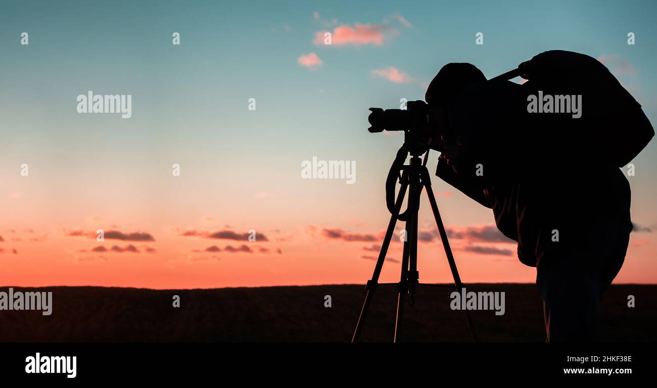 Silhouette of a photographer on a sunset background with a tripod Stock ...