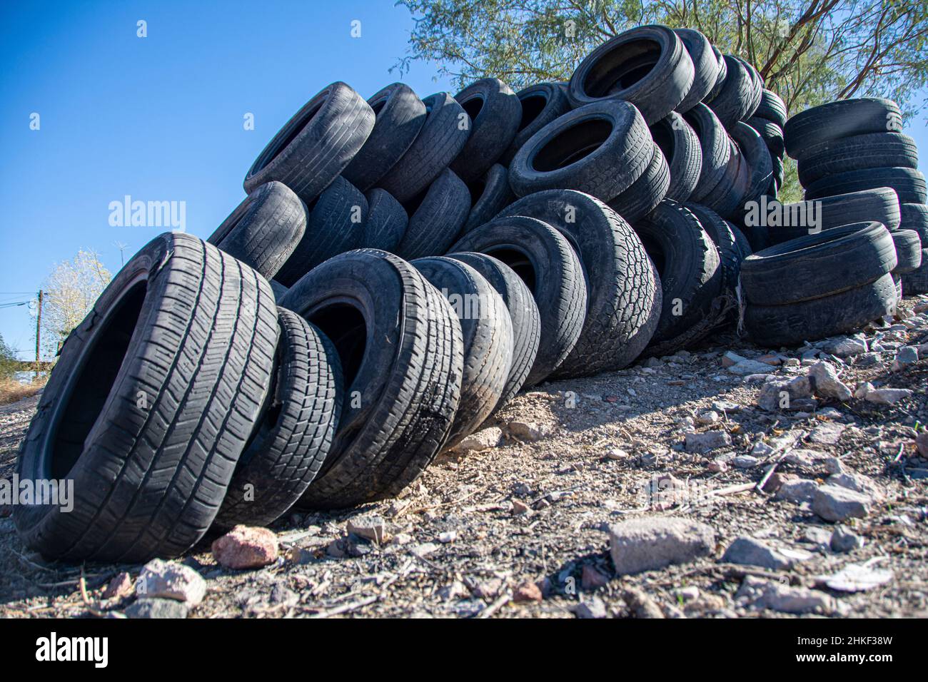 A large group of discarded vehicle tires. Outside of a tire store